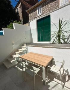 a wooden table and chairs on a patio at Apartment Dolce by DuBooker in Trpanj
