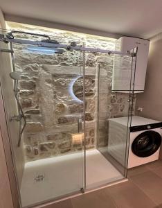 a shower in a bathroom with a stone wall at Apartment Dolce by DuBooker in Trpanj