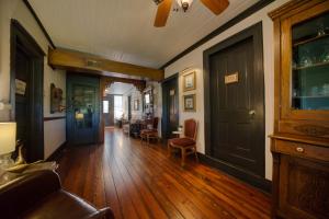 a living room with wooden floors and a door at Downtown Chantilly Ste Piedmont in Eureka Springs