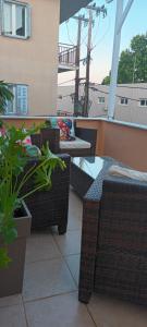 a patio with wicker chairs and a table on a balcony at Aphrodite luxury rooms in Mytilene