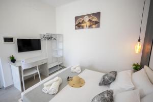 a living room with a white couch and a desk at Esmeralda Guest House in Cinisi