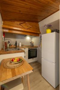 a kitchen with a white refrigerator and a bowl of fruit on a table at A casa da avó Tina in Montemor-o-Novo
