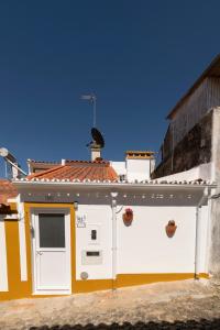 a white and yellow building with a door at A casa da avó Tina in Montemor-o-Novo