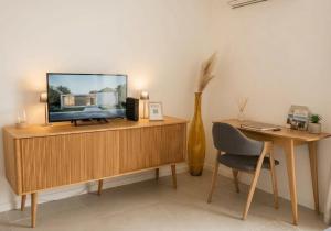 a living room with a television on a wooden cabinet at Seaview.Cassis in Cassis