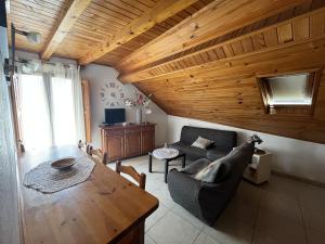 a living room with a wooden ceiling and a table at Casa Campaner in Valencia de Aneu