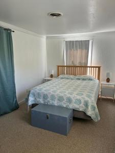 a bedroom with a bed and a blue box on the floor at Captain's Quarters in Avon