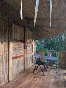 a table and chairs on the porch of a cabin at Adama Eco Farm in Santa Catalina