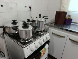 a kitchen with two pots and pans on a stove at Pousada Paraíso in Telêmaco Borba