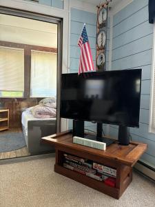 a flat screen tv sitting on a table in a room at Captain's Quarters in Avon