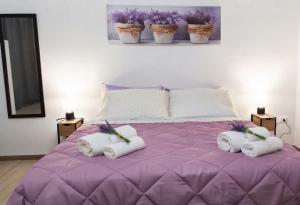 a purple bed with towels on top of it at S'apposentu 'e Santa Ruche in Oniferi