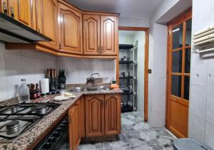 a kitchen with wooden cabinets and a sink at Gran Areatxa Home Mountain in Santiago de la Espada