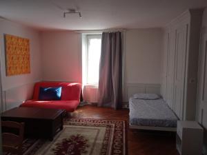 a living room with a red couch and a window at Chambre C room in Biel