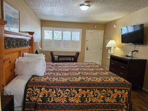 a hotel room with a bed and a flat screen tv at San Luis Inn and Suites in San Luis Obispo