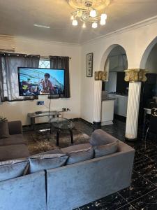 a living room with a couch and a flat screen tv at Rashlie apartment in Freetown