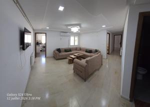 a living room with a couch and a table at Appartement Iris in Gabès