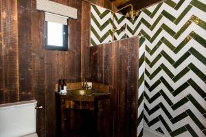 a bathroom with a sink and a checkered wall at Oak - The Nook Lodges in Wrenbury +32 photos