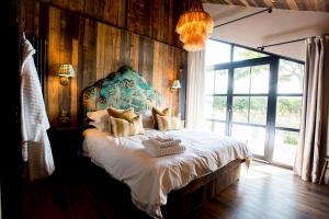 a bedroom with a large bed with a large window at Oak - The Nook Lodges in Wrenbury