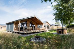 a wooden house with a gambrel roof at Oak - The Nook Lodges in Wrenbury