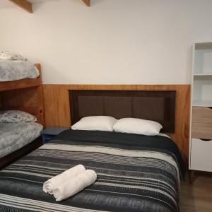 a bedroom with a bed with two towels on it at Ruta 7 in Coihaique