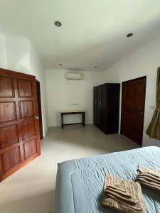 a bedroom with a bed and a wooden door at olivia village pool resort in Mae Nam
