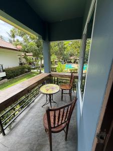 a patio with two chairs and a table on a balcony at olivia village pool resort in Mae Nam