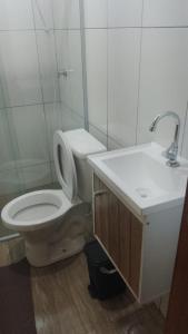 a bathroom with a toilet and a sink at Pousada Paraíso in Telêmaco Borba +4 photos