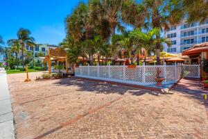 a resort with palm trees and a white fence at Blue Seas Courtyard in Fort Lauderdale
