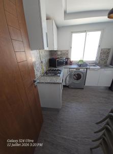 a kitchen with a stove and a washing machine at Appartement Iris in Gabès