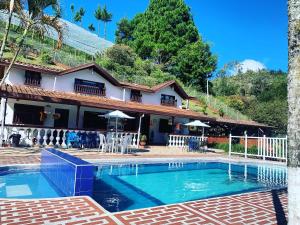 a swimming pool in front of a house at Finca Hotel Mariangel in El Peñol