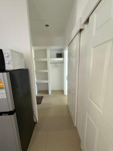 a hallway with a white door and a kitchen at olivia village pool resort in Mae Nam