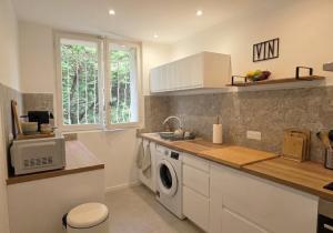 a kitchen with a washing machine and a window at Seaview.Cassis in Cassis