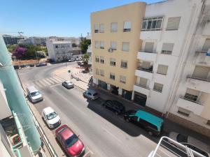 a view of a city street with cars parked on the road at Cubo Rooms Olhão in Olhão