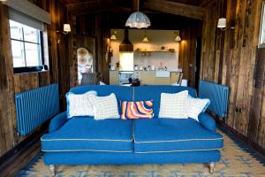 a blue couch in a room with a kitchen at Iris - The Nook Lodges in Nantwich