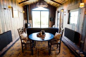 a table and chairs in a room with a window at Iris - The Nook Lodges in Nantwich