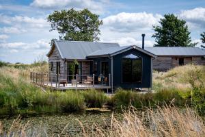 a blue cabin in the middle of a field at Iris - The Nook Lodges in Nantwich +16 photos