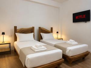 two twin beds in a room with a sign on the wall at Villa Monte Shpirag in Berat