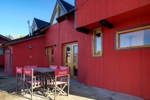 a red building with a table and chairs outside at Complejo Casa Roja in Dina Huapi