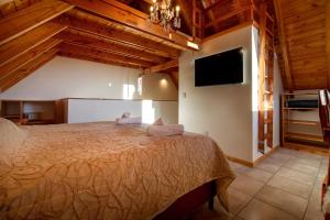 a bedroom with a bed and a flat screen tv at Complejo Casa Roja in Dina Huapi