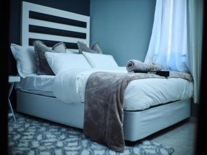 a bedroom with a white bed with a blanket on it at P Daisy in Rundu