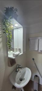 a bathroom with a white sink and a mirror at Hera's Hideaway in Samos