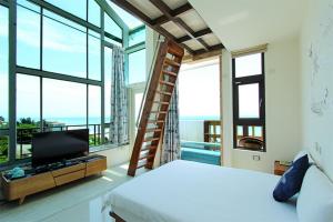a bedroom with a bed and a television and windows at Water Ripple in Yanliau