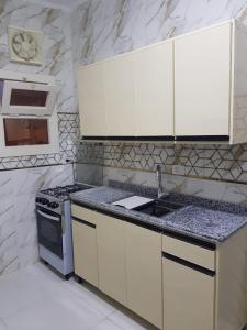a white kitchen with a sink and a stove at Holiday Home Matrouh in Marsa Matruh