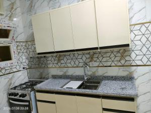a kitchen with white cabinets and a sink at Holiday Home Matrouh in Marsa Matruh