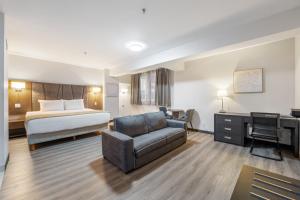 a hotel room with a bed and a couch and a desk at Hotel Montreal Metropolitan, an Ascend Collection Hotel in Montreal