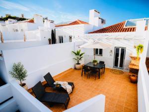 a patio with a table and chairs and white buildings at Iconic Vila d'Obidos in Óbidos