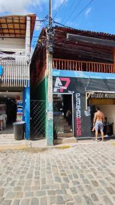 a man standing in front of a building at Casa Hostel da Cida in Pipa