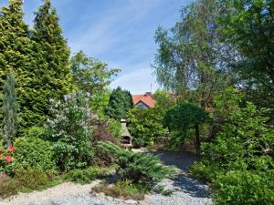 a garden with trees and a house in the background at Aparthotel STUDIO in Krakow