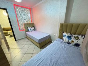a small room with two beds and a mirror at Cozy Ajanif Suite in Martil +4 photos