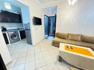 a living room with a couch and a kitchen at Cozy Ajanif Suite in Martil