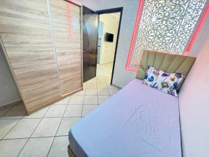 a bedroom with a purple bed in a room at Cozy Ajanif Suite in Martil